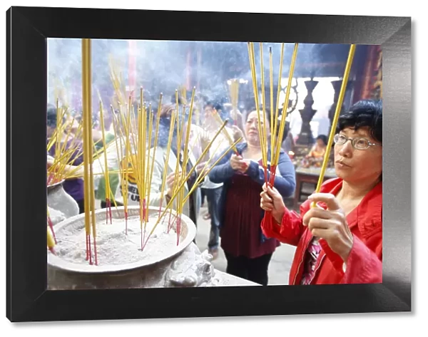 Burning incense during Tet, the Vietnamese lunar New Year celebration, Thien Hau Temple