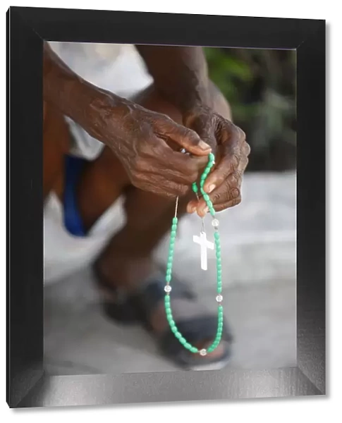 Haitian woman praying with prayer beads, Port au Prince, Haiti, West Indies