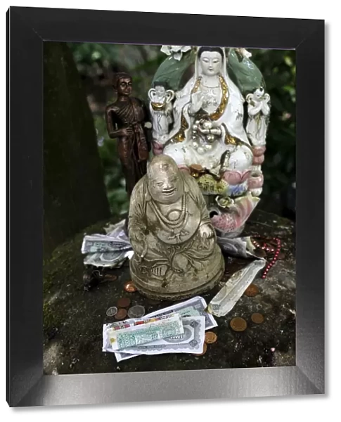 Money offering and statues in the garden of Buddhapadipa temple, Wimbledon, London
