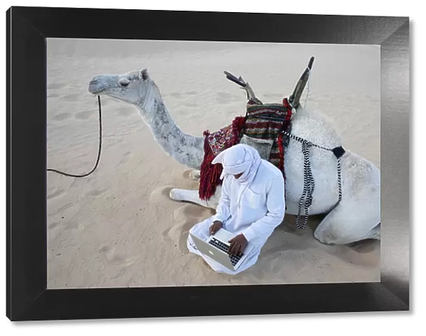 Bedouin using a laptop in the Sahara, Douz, Kebili, Tunisia, North Africa, Africa