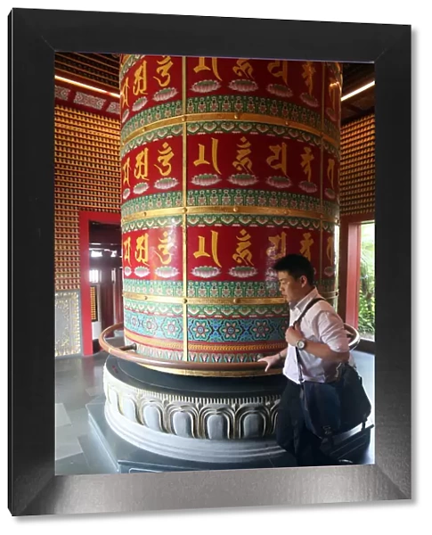 Worshipper and Viarocana Buddhist prayer wheel, Buddha Tooth Relic Temple in Chinatown
