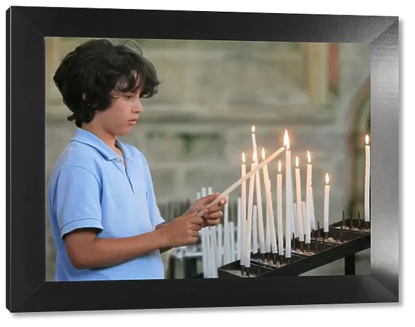 Boy lighting a church candle