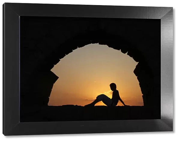 Girl watching sunset in Cesarea, Israel, Middle East
