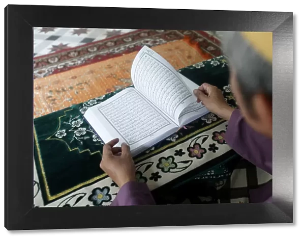 Muslim man reading an Arabic Holy Quran (Koran), Saigon Central Mosque, Ho Chi Minh City