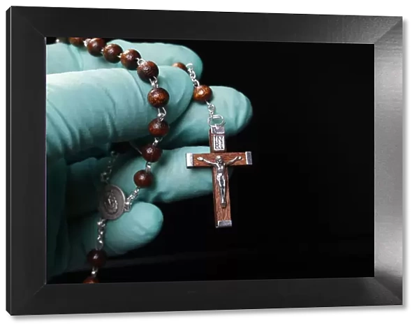Coronavirus (COVID-19) epidemic, Christian praying rosary beads with protecting glove