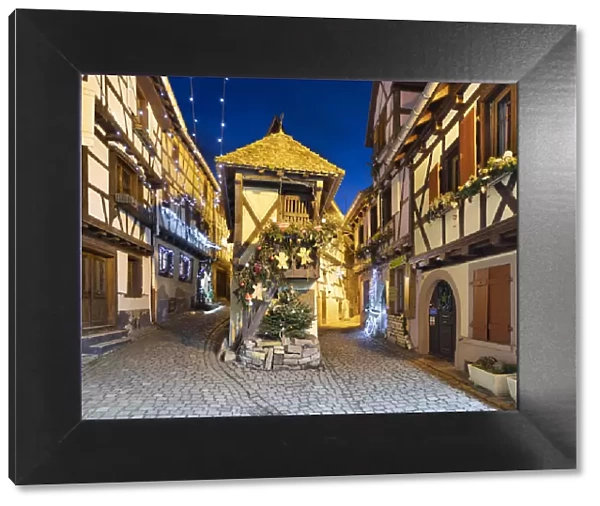 Half-timbered houses along Rue du Rempart Sud lit up with Christmas decorations at night