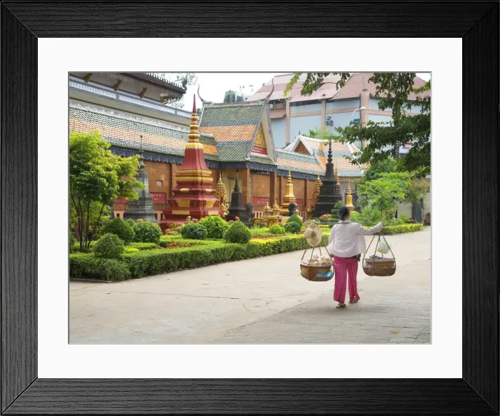 Framed Print : Woman carrying baskets over her shoulders outside a temple in Siem Reap, Cambodia Framed Print : Woman carrying baskets over her shoulders outside a temple in Siem Reap, Cambodia