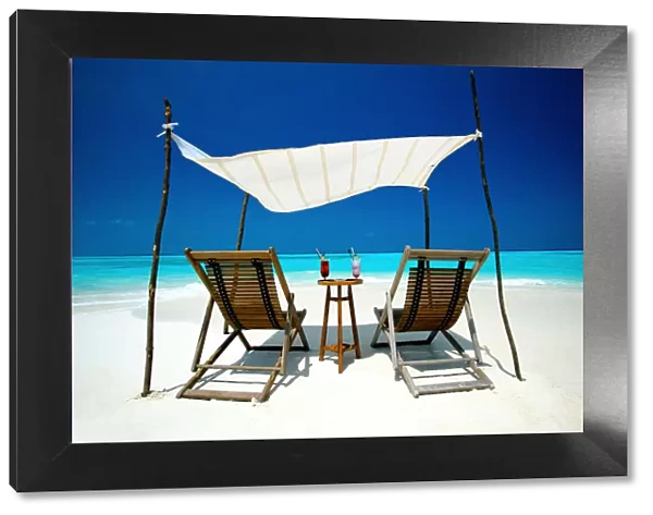 Two deck chairs under shelter on beach, Maldives, Indian Ocean, Asia