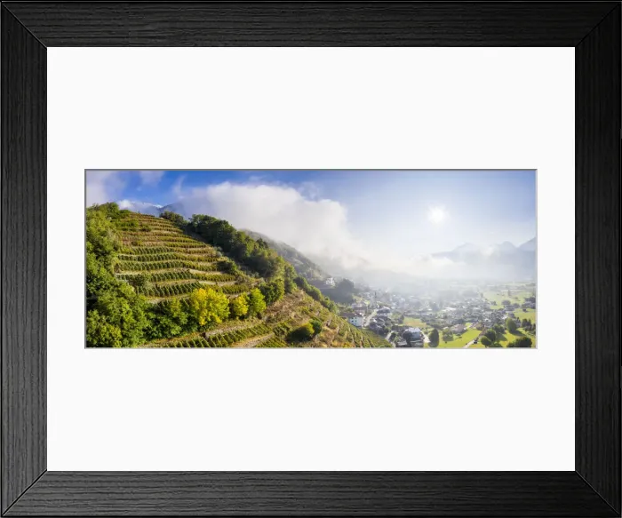 Framed Print : Aerial panoramic view of vineyards with village illuminated by sun in autumn, Berbenno
