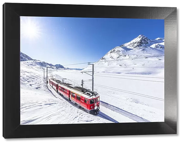 Bernina Express transit along Lago Bianco in winter, Bernina Pass, Engadine