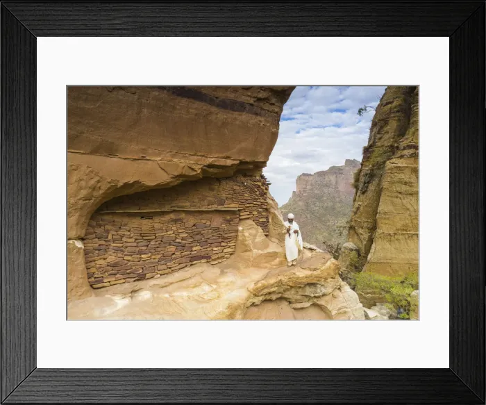 Framed Print : Priest holding the hand cross on rocks outside Abuna Yemata Guh church Framed Print : Priest holding the hand cross on rocks outside Abuna Yemata Guh church