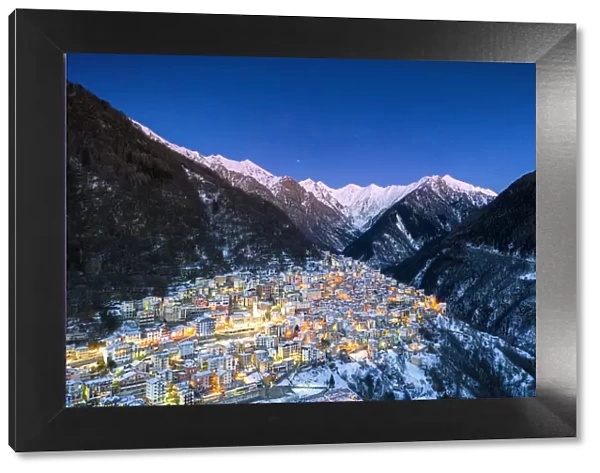 View by drone of winter dusk over the illuminated village of Premana, Valsassina