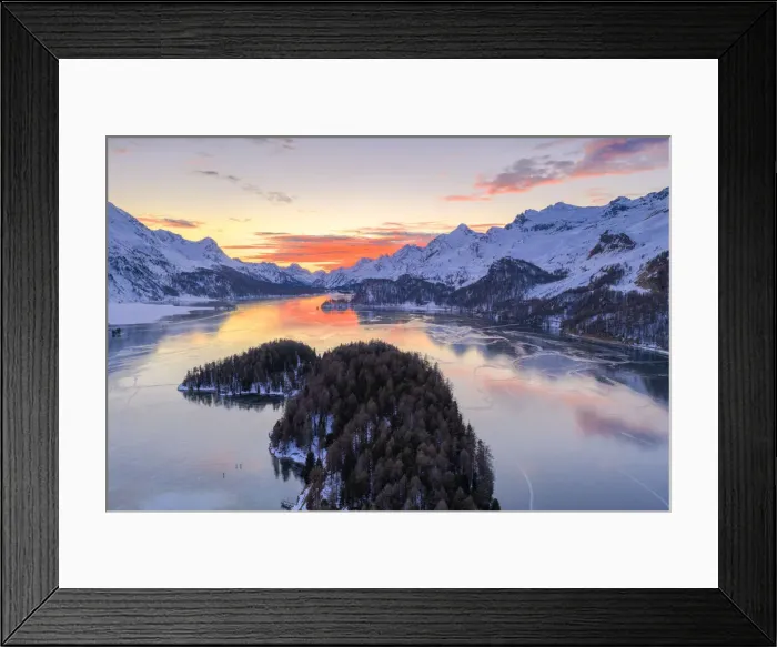 Framed Print : Aerial view of burning sky at sunset on frozen Lake Sils and snow capped mountains