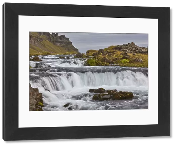 A classic Icelandic landscape, a river flowing along the base of a cliff