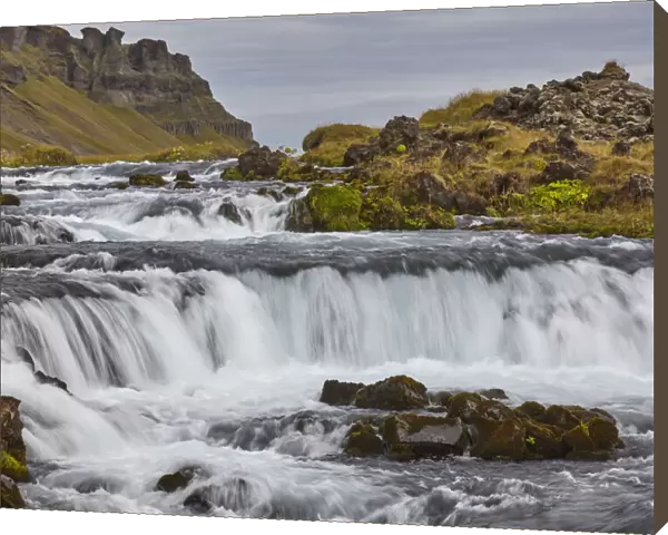 A classic Icelandic landscape, a river flowing along the base of a cliff