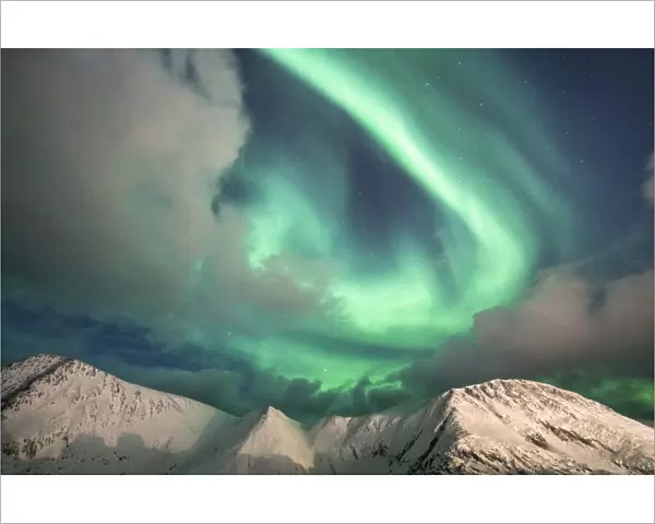 Northern Lights (Aurora Borealis) over mountain peaks covered with snow, Sorvaer