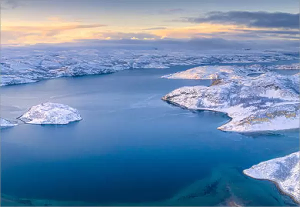 Arctic sunrise over the frozen sea and mountains covered with snow, Laksefjorden, Lebesby