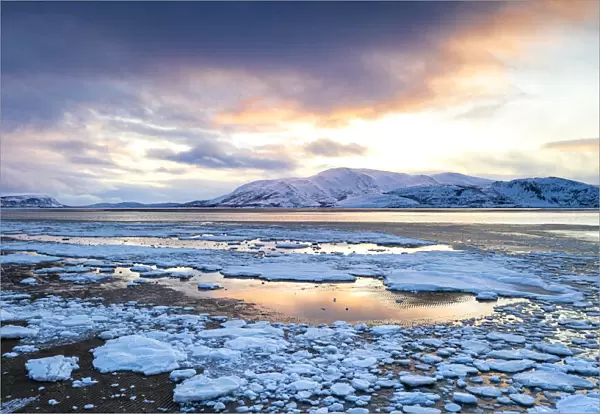 Arctic sunset on snow capped mountains and frozen sea, Tanamunningen Nature Reserve