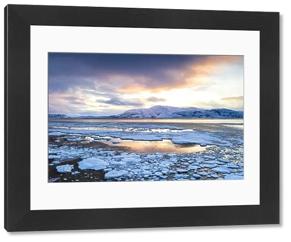 Arctic sunset on snow capped mountains and frozen sea, Tanamunningen Nature Reserve