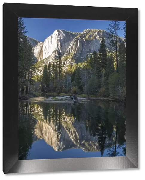 High granite cliffs reflected in the tranquil Merced River, autumn, Yosemite Village