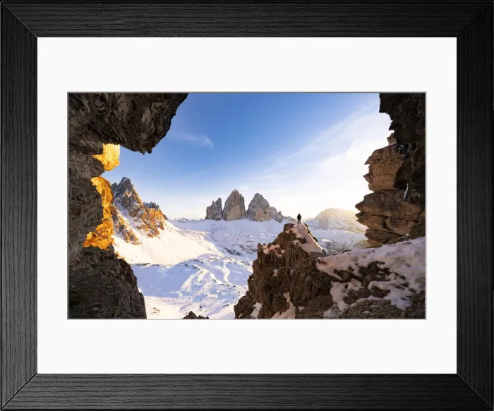 Framed Print : Hiker on rocks admiring Tre Cime di Lavaredo and Monte Paterno covered with snow Framed Print : Hiker on rocks admiring Tre Cime di Lavaredo and Monte Paterno covered with snow