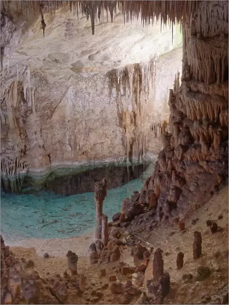 Flooded limestone cave interior with many stalactites and stalagmites and reflections