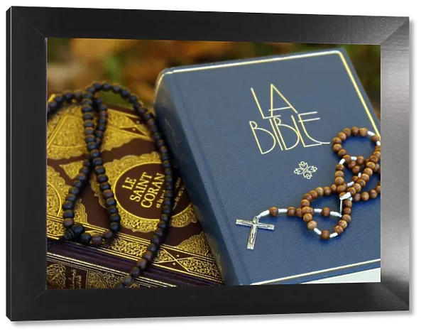 Holy Quran in French with Muslim prayer beads and Bible with rosary