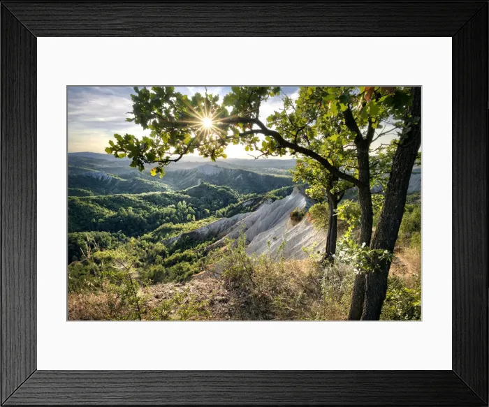 Framed Print : Badlands and green hills framed by trees and a sunburst, Emilia Romagna, Italy, Europe Framed Print : Badlands and green hills framed by trees and a sunburst, Emilia Romagna, Italy, Europe