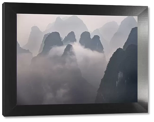 Misty morning with fog and low clouds on the peaks above Li River, Guangxi, China, Asia