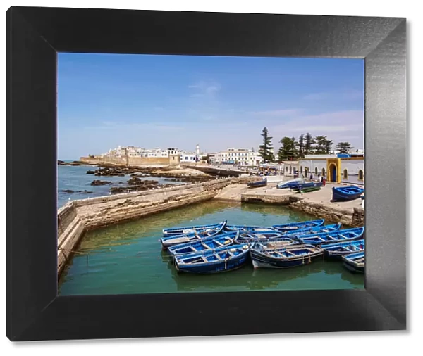 Cityscape with blue boats in the Scala Harbour and the Medina city walls, Essaouira