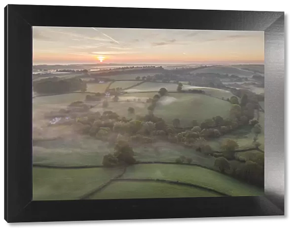 Misty spring sunrise over rolling countryside, South Tawton, Devon, England