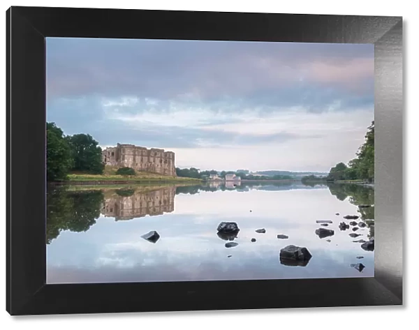Carew Castle reflected in the mill pond at dawn, Pembrokeshire, Wales, United Kingdom