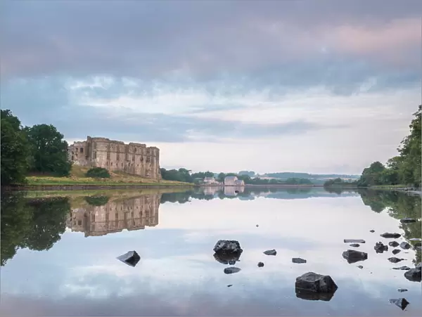 Carew Castle reflected in the mill pond at dawn, Pembrokeshire, Wales, United Kingdom