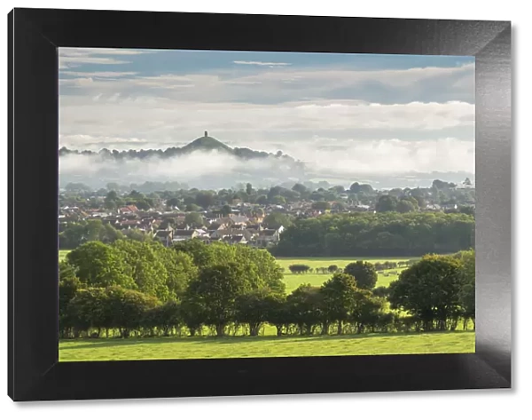 View across the town of Street towards Glastonbury Tor on a misty autumn morning