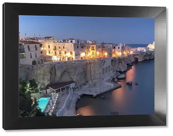Illuminated pool of luxury resort by the sea at dusk in Vieste old town, Foggia province
