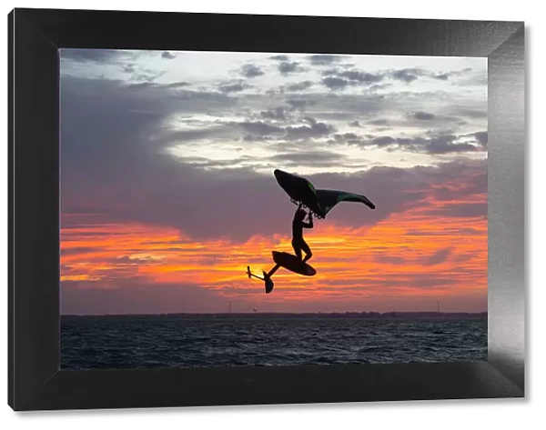 Pro surfer James Jenkins jumps his wing surfer at sunset over the Pamlico Sound at Nags