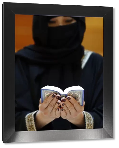 Muslim woman reading the Noble Quran, United Arab Emirates, Middle East
