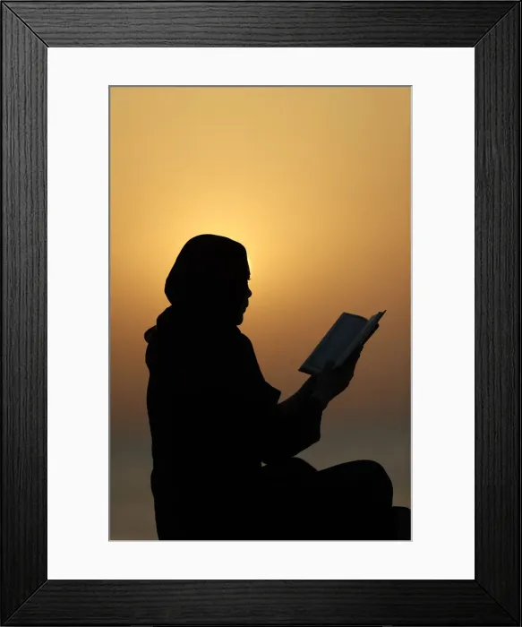 Framed Print : Silhouette of a Muslim woman reading the Noble Quran at sunset, United Arab Emirates Framed Print : Silhouette of a Muslim woman reading the Noble Quran at sunset, United Arab Emirates