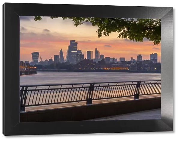 View of The City skyline at sunset from the Thames Path, London, England, United Kingdom