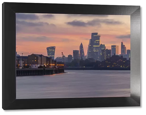 View of The City skyline at sunset from the Thames Path, London, England, United Kingdom