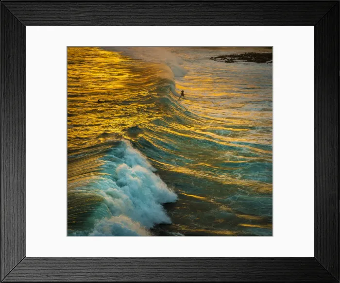 Framed Print : A surfer catches a wave in the golden reflections of the sunset on the south shore of Framed Print : A surfer catches a wave in the golden reflections of the sunset on the south shore of