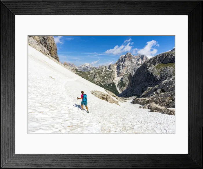 Framed Print : Hiker woman walking on snowy mountain ridge on path to Rifugio Locatelli hut Framed Print : Hiker woman walking on snowy mountain ridge on path to Rifugio Locatelli hut