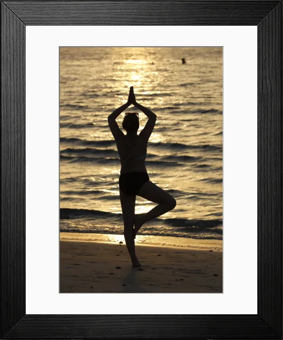 Framed Print : Woman practising yoga meditation on beach at sunset as concept for silence and relaxation Framed Print : Woman practising yoga meditation on beach at sunset as concept for silence and relaxation