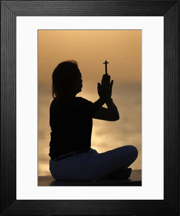 Framed Print : Silhouette of faithful woman praying with Christian cross at sunset as concept for Framed Print : Silhouette of faithful woman praying with Christian cross at sunset as concept for
