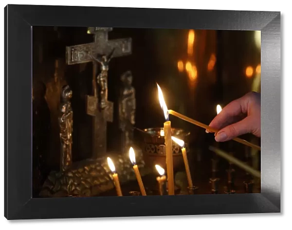 Faithful lighting a candle in Saint Teaodor Tiron (Ciuflea) Cathedral and Monastery
