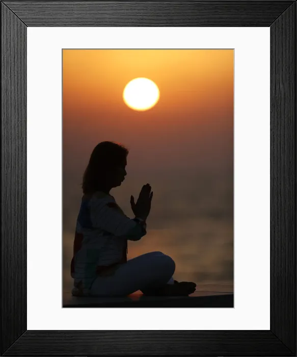 Framed Print : Woman practising yoga pose and meditation at sunset as concept for silence and relaxation Framed Print : Woman practising yoga pose and meditation at sunset as concept for silence and relaxation
