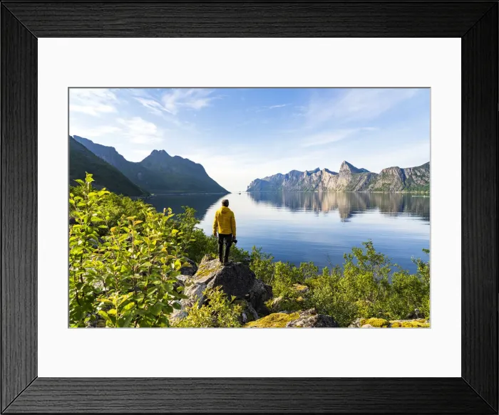 Framed Print : Rear view of photographer admiring the Mefjord blue water standing on rocks, Senja Framed Print : Rear view of photographer admiring the Mefjord blue water standing on rocks, Senja