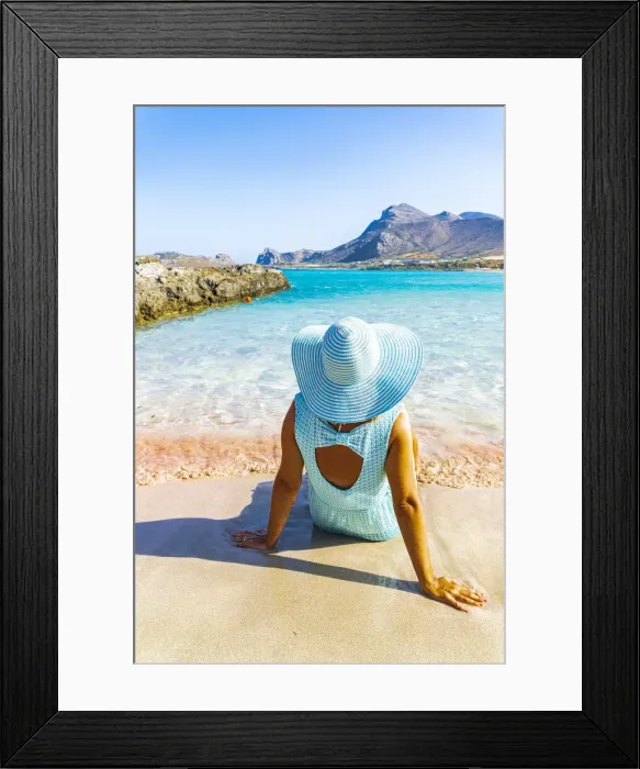 Framed Print : Back view of woman contemplating the sea sitting on pink sand of Falassarna beach Framed Print : Back view of woman contemplating the sea sitting on pink sand of Falassarna beach