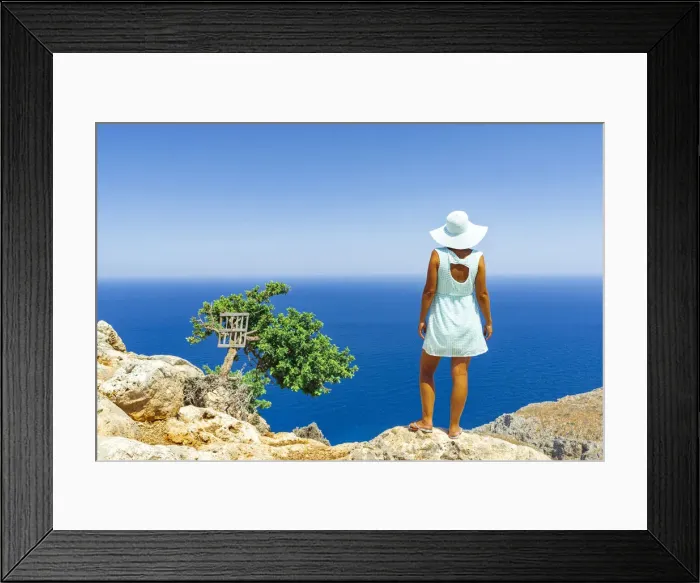 Framed Print : Back view of woman with fashion dress and hat looking at the sea from cliffs, Crete Framed Print : Back view of woman with fashion dress and hat looking at the sea from cliffs, Crete