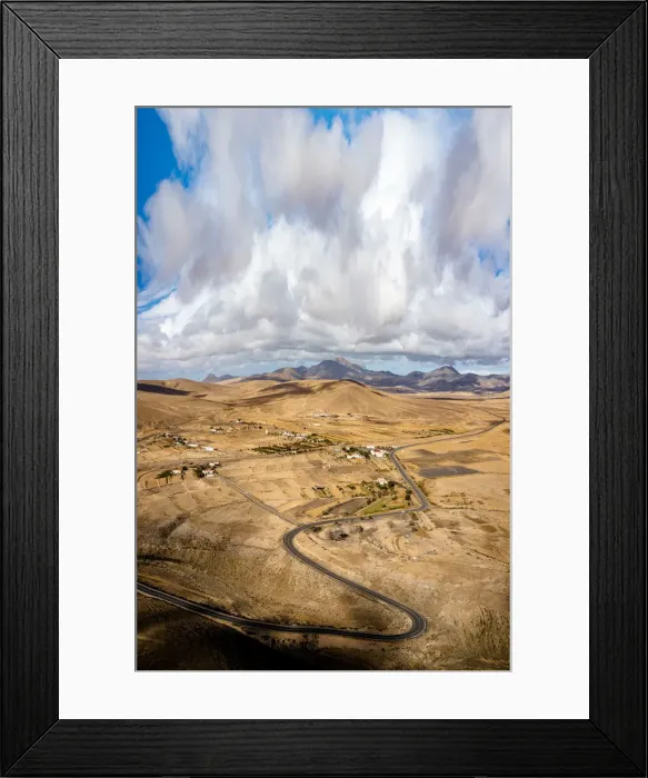 Framed Print : Scenic clouds on winding road running through desert mountains, aerial view, Tefia Framed Print : Scenic clouds on winding road running through desert mountains, aerial view, Tefia